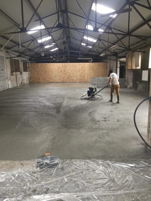 Lissage du béton frais dans le hangar de la brasserie Mazesté